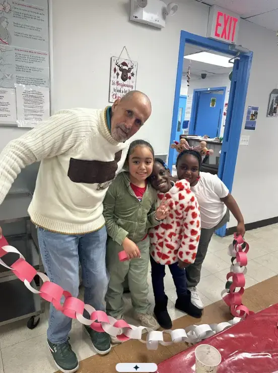 Teacher and three students holding a paper chain holiday decoration