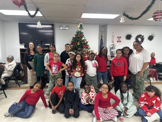 Students and staff posing together at a holiday Christmas party