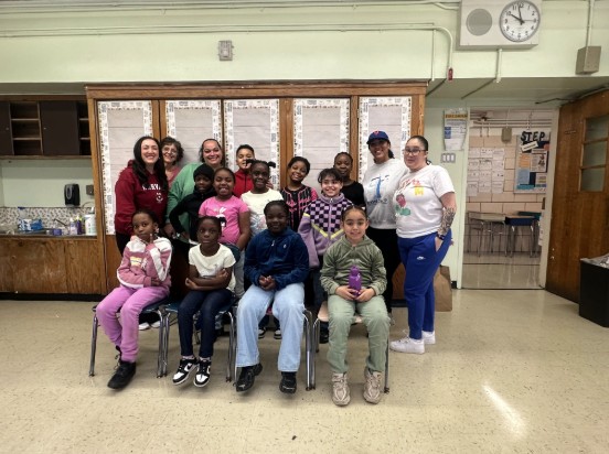 Students and staff pose together in a school classroom