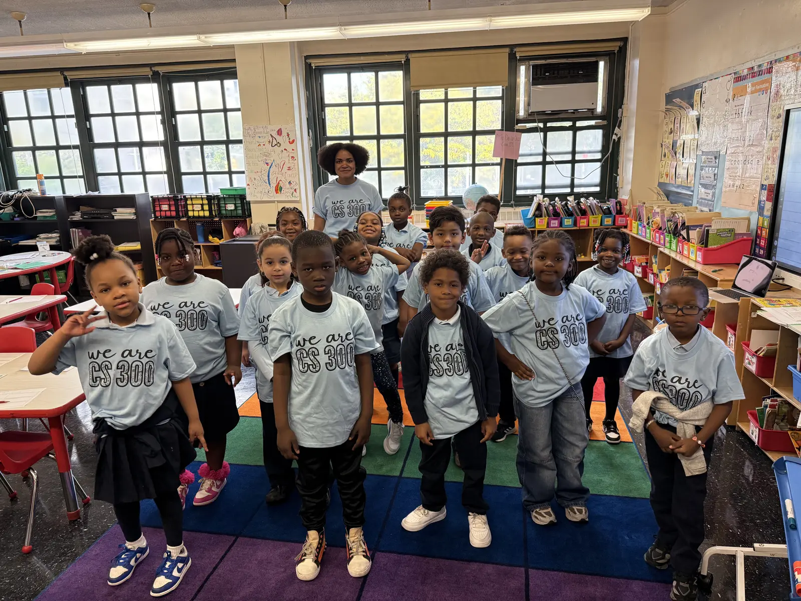 CS 300 students and teacher wearing matching school spirit shirts in classroom