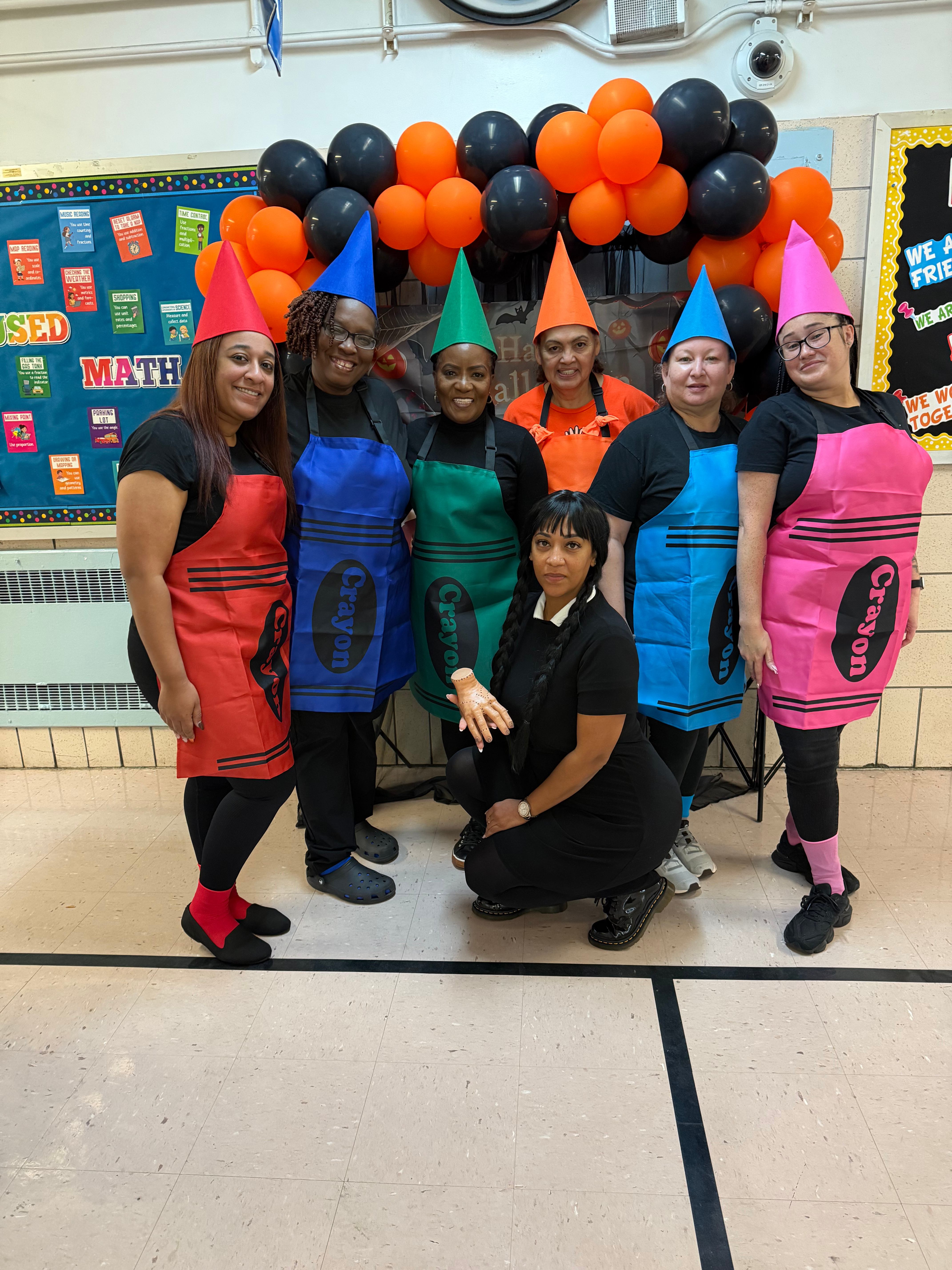 School staff dressed as colorful crayons at Halloween celebration