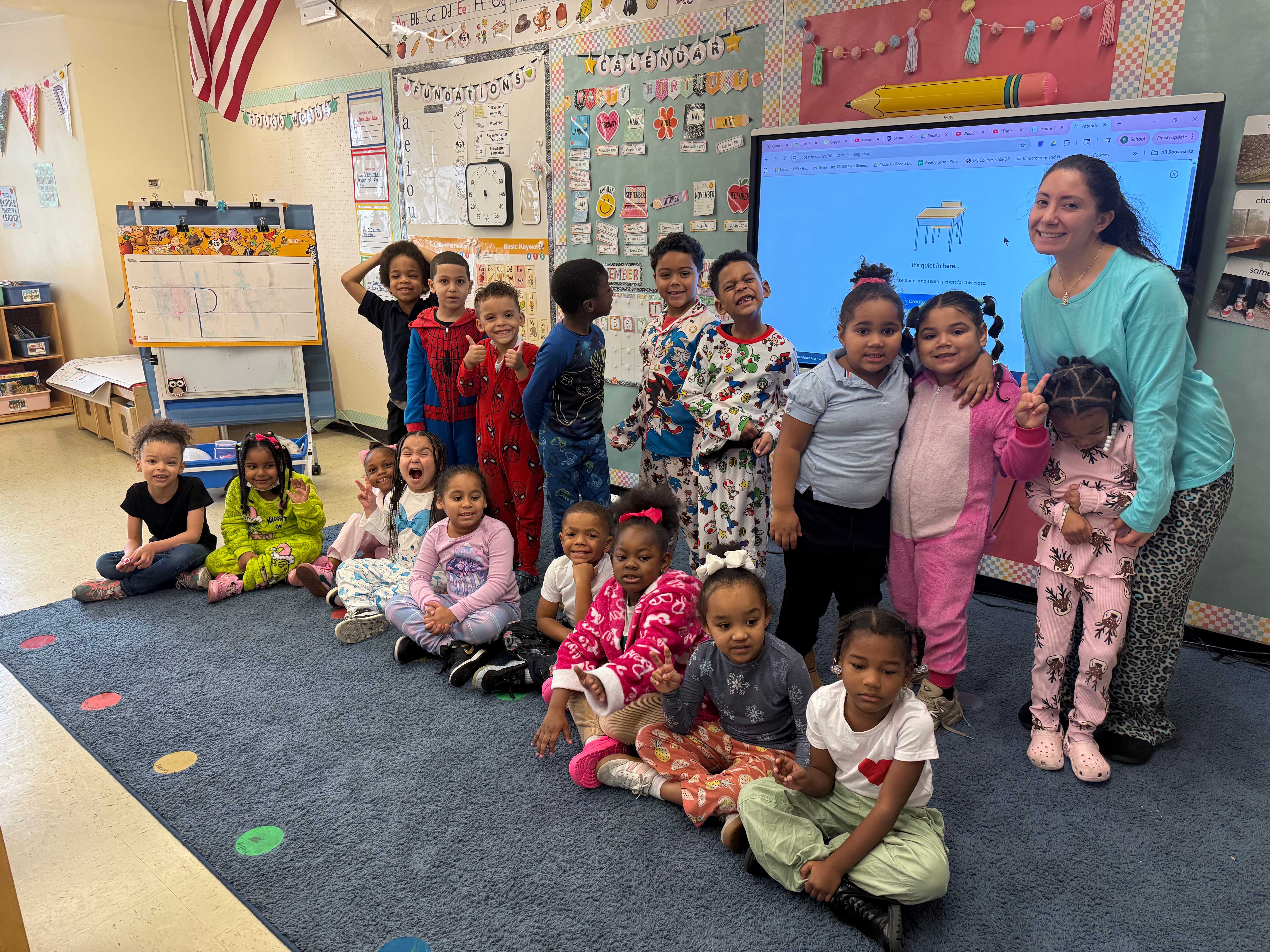 Teacher and students posing together in pajamas during classroom spirit day