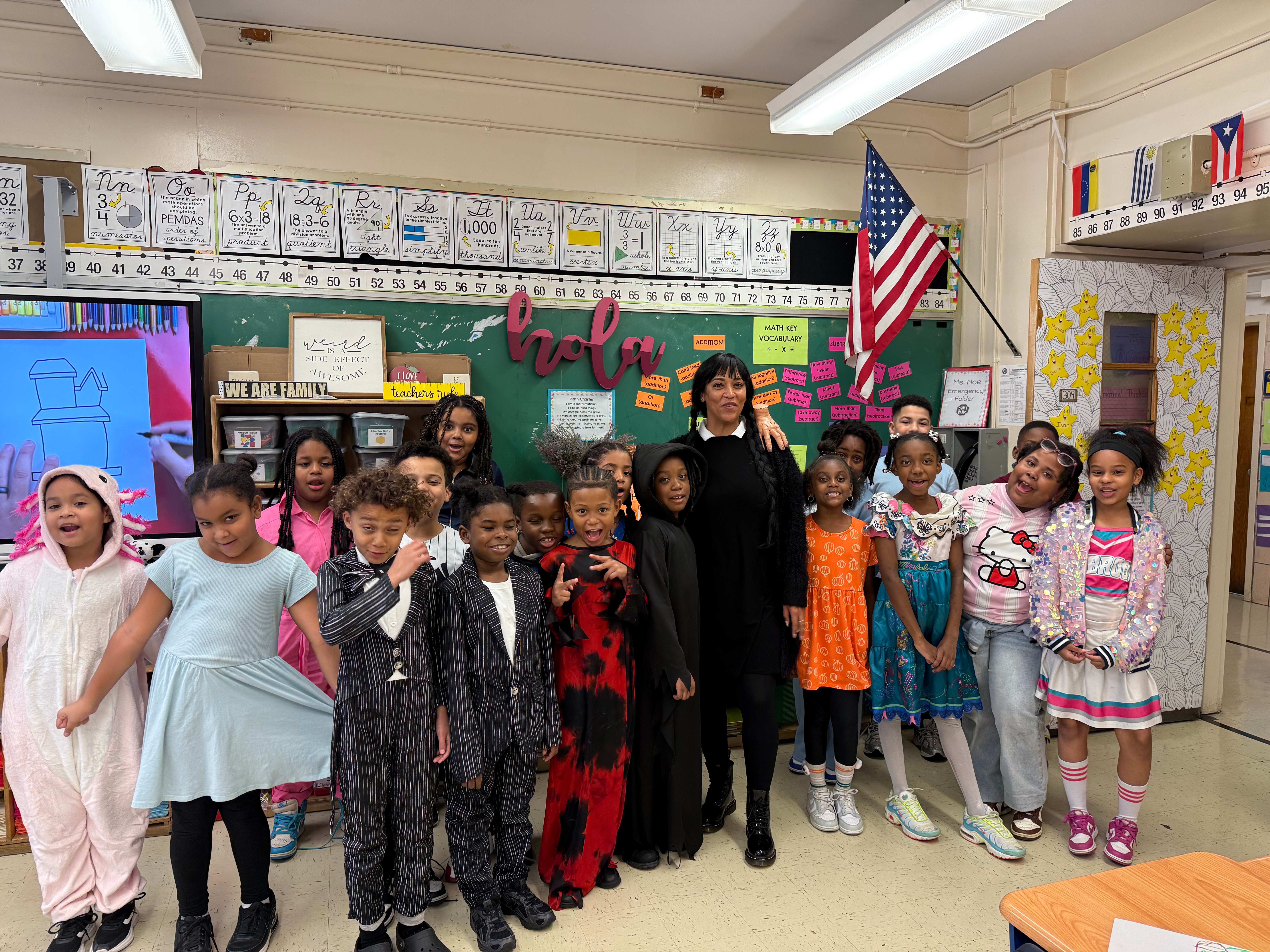 Teacher and students posing in costumes during Halloween classroom celebration