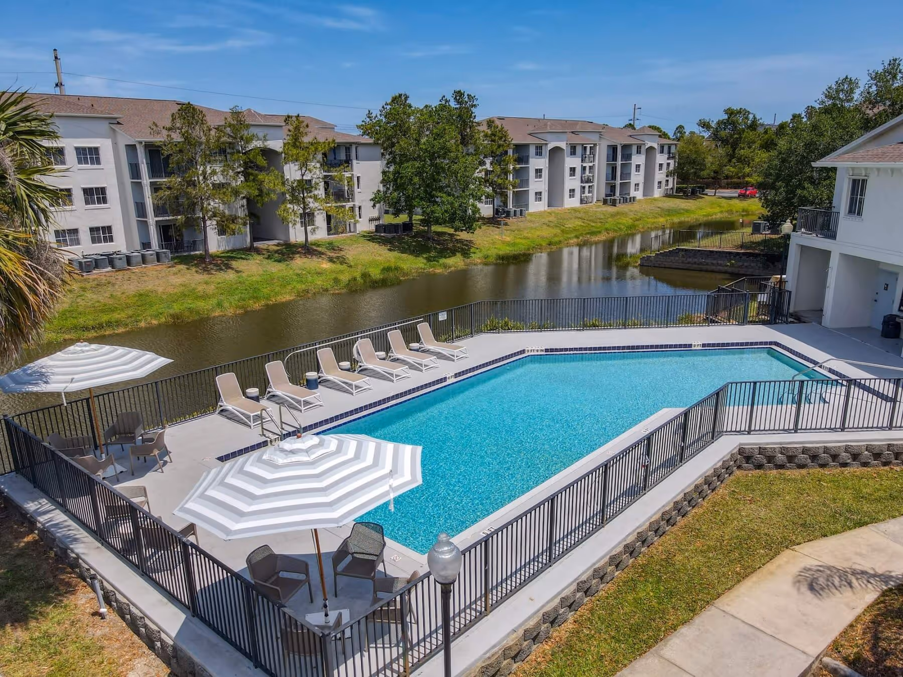 Aerial view of pool, apartments, and lake