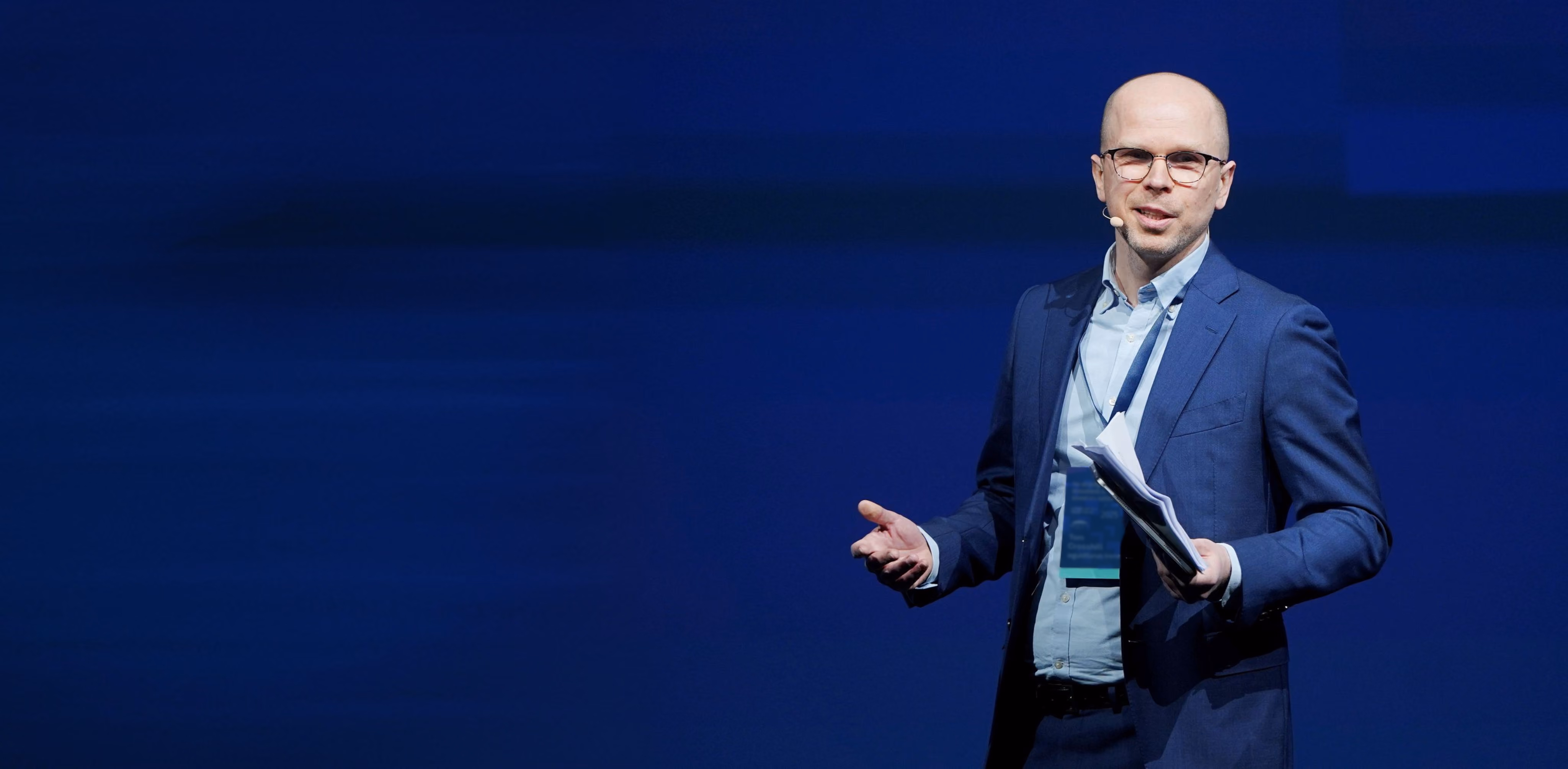 Tom Crosshill speaking on stage at an investing conference