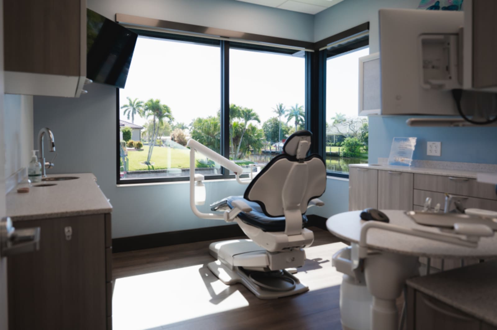 Modern dental treatment room with large windows, patient chair, and natural lighting overlooking landscape