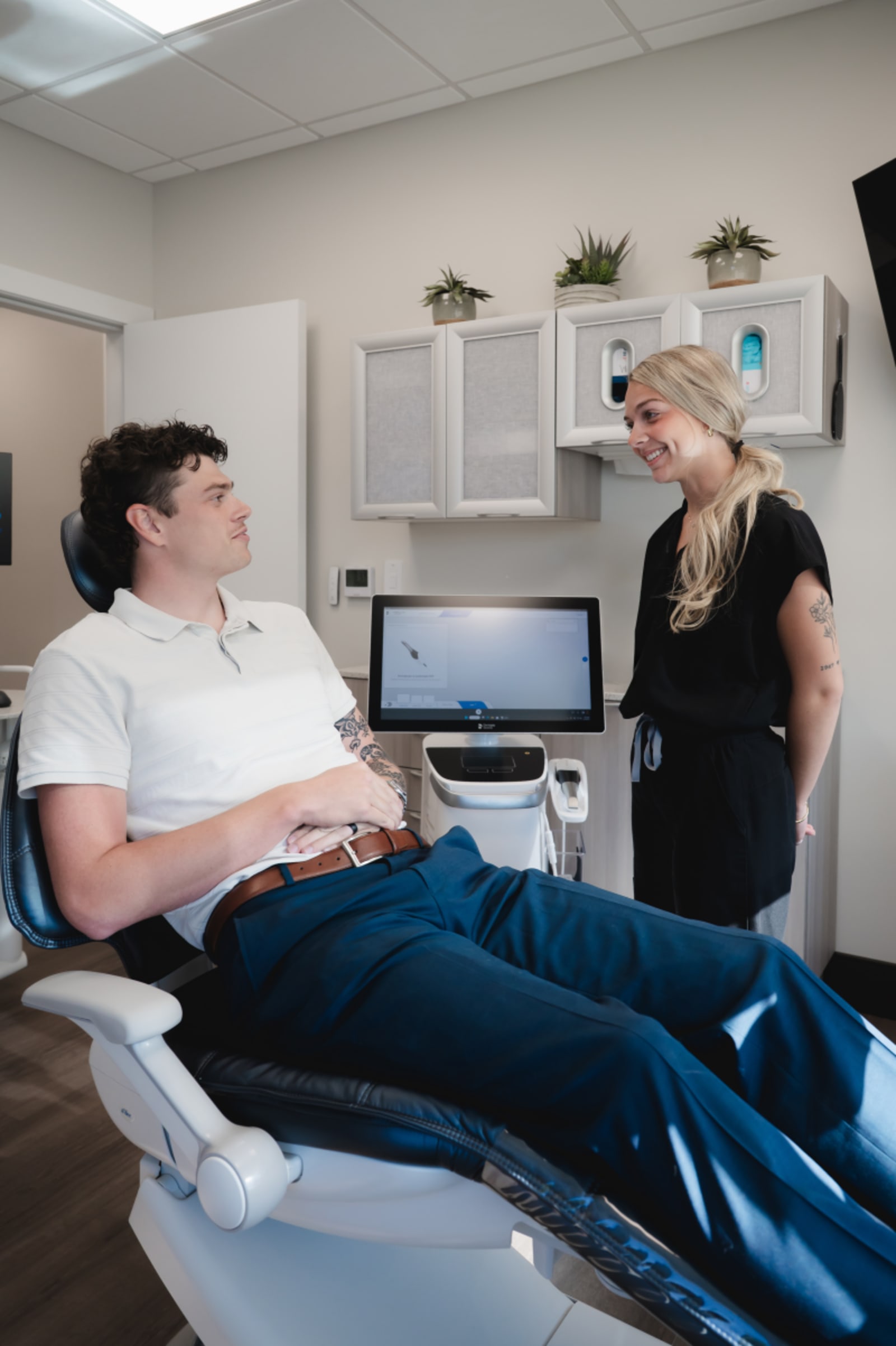 Dentist greeting male patient in dental chair for first appointment consultation