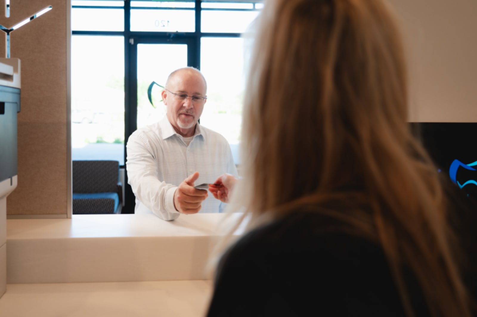Female patient consulting with male dentist in modern dental office during consultation.