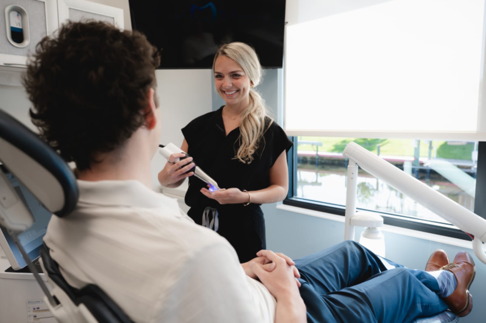 Dentist showing young patient dental shade guide during consultation with welcoming interaction