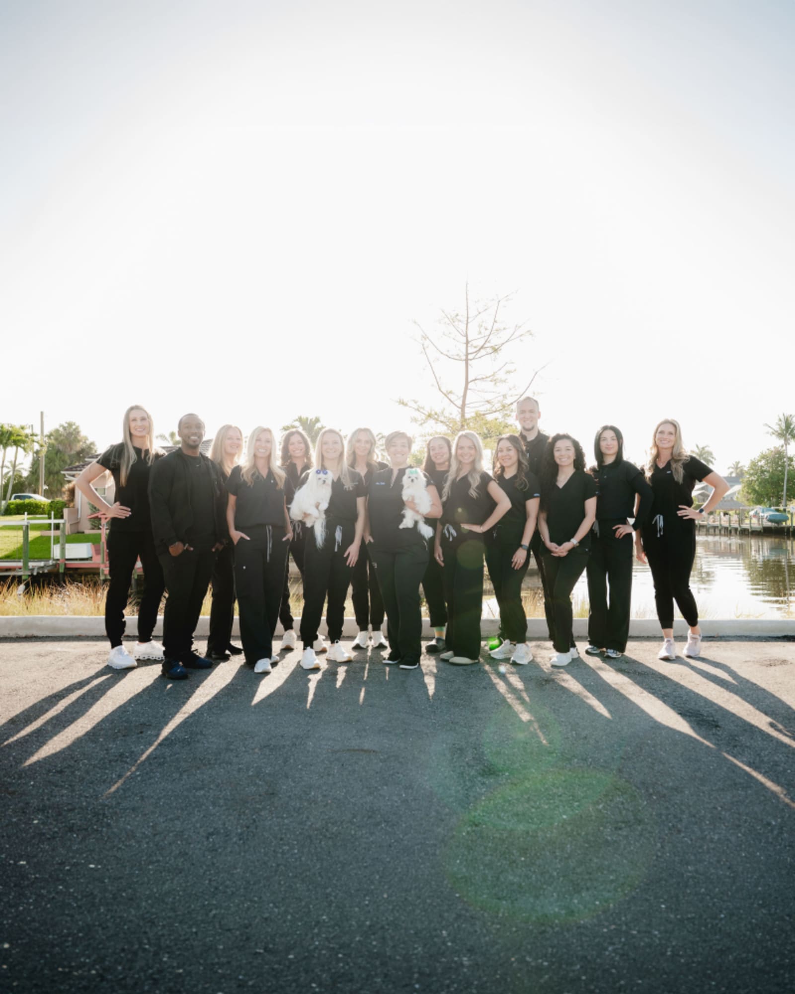 Kari Mann Dental Studio team standing together on a street with city skyline in background.