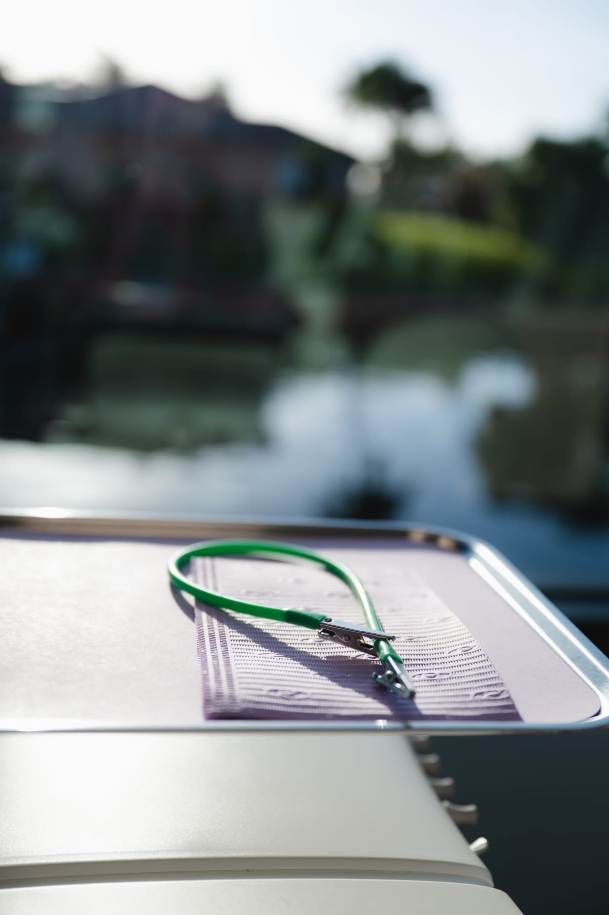 Eyeglasses resting on a notebook near a waterside landscape view.