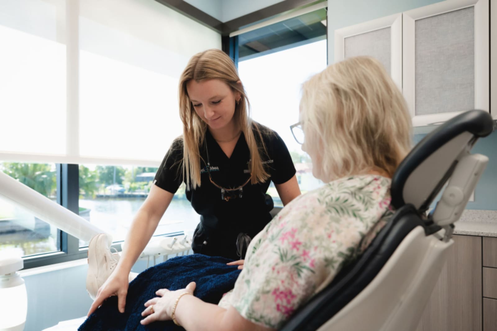 Female dentist discussing treatment options with an older female patient in treatment room