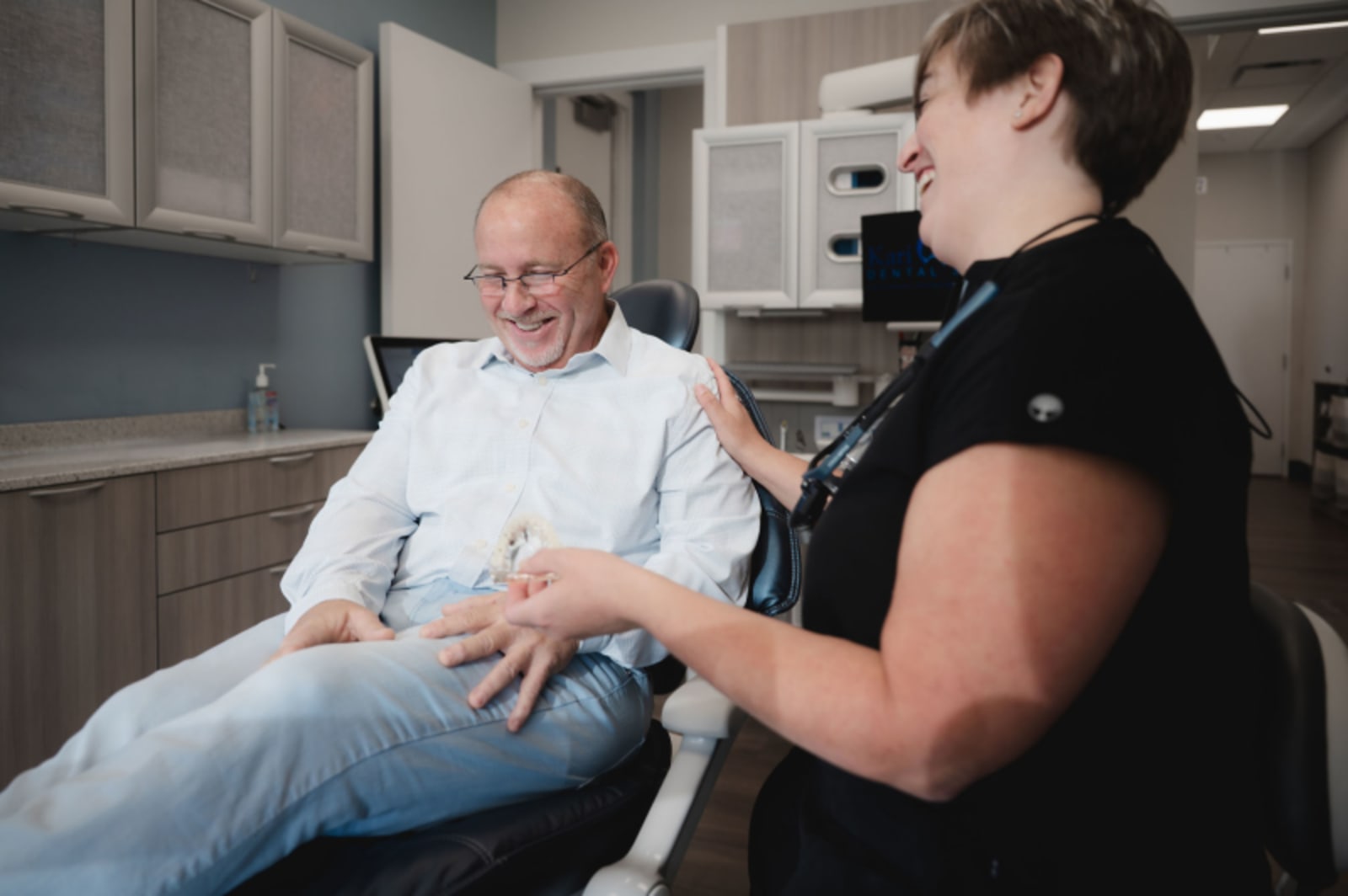 Dentist consulting with male patient about jaw tension and dental treatment options