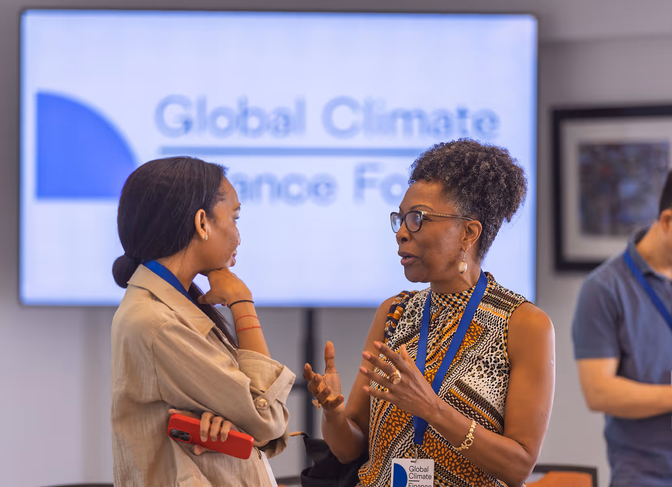 Five people seated in a panel discussion with a screen behind them displaying 'Global Climate Finance Forum'.