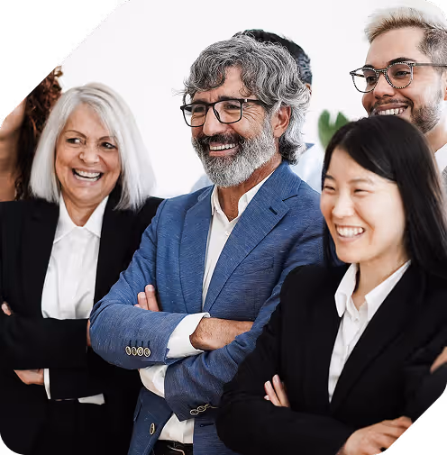 Group of diverse business professionals smiling and standing together with arms crossed in a bright office setting.