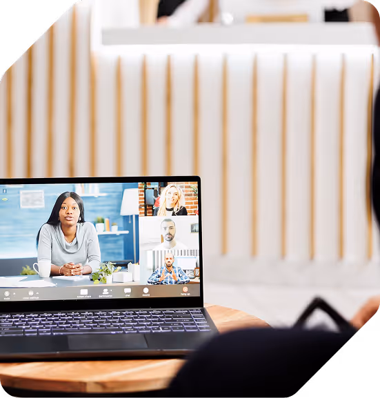 Person attending a virtual meeting on a laptop with three other participants visible on screen.