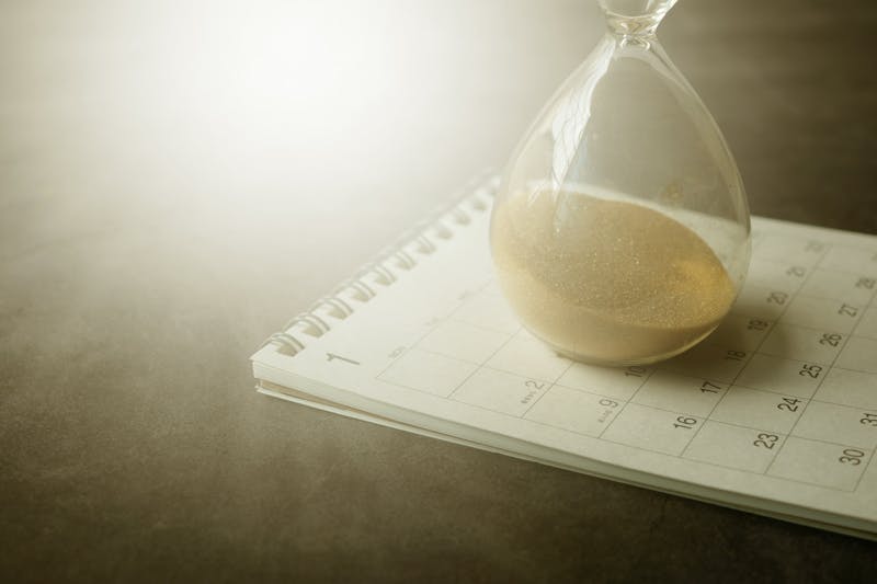 Calendar and hourglass on a desk representing deadlines