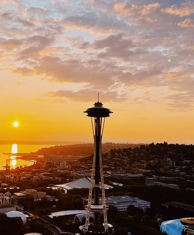 Sunset view of the Space Needle overlooking Seattle cityscape and waterfront.