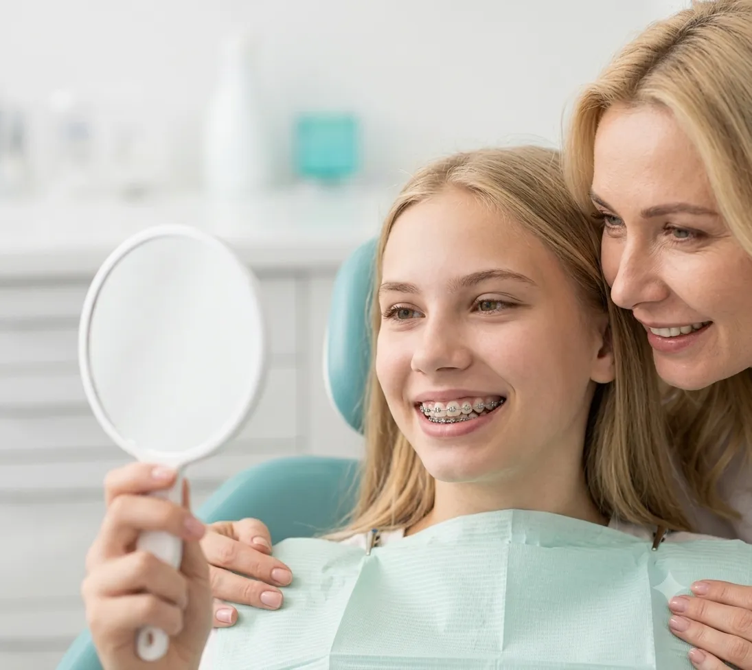 Teen smiling with braces in orthodontic chair