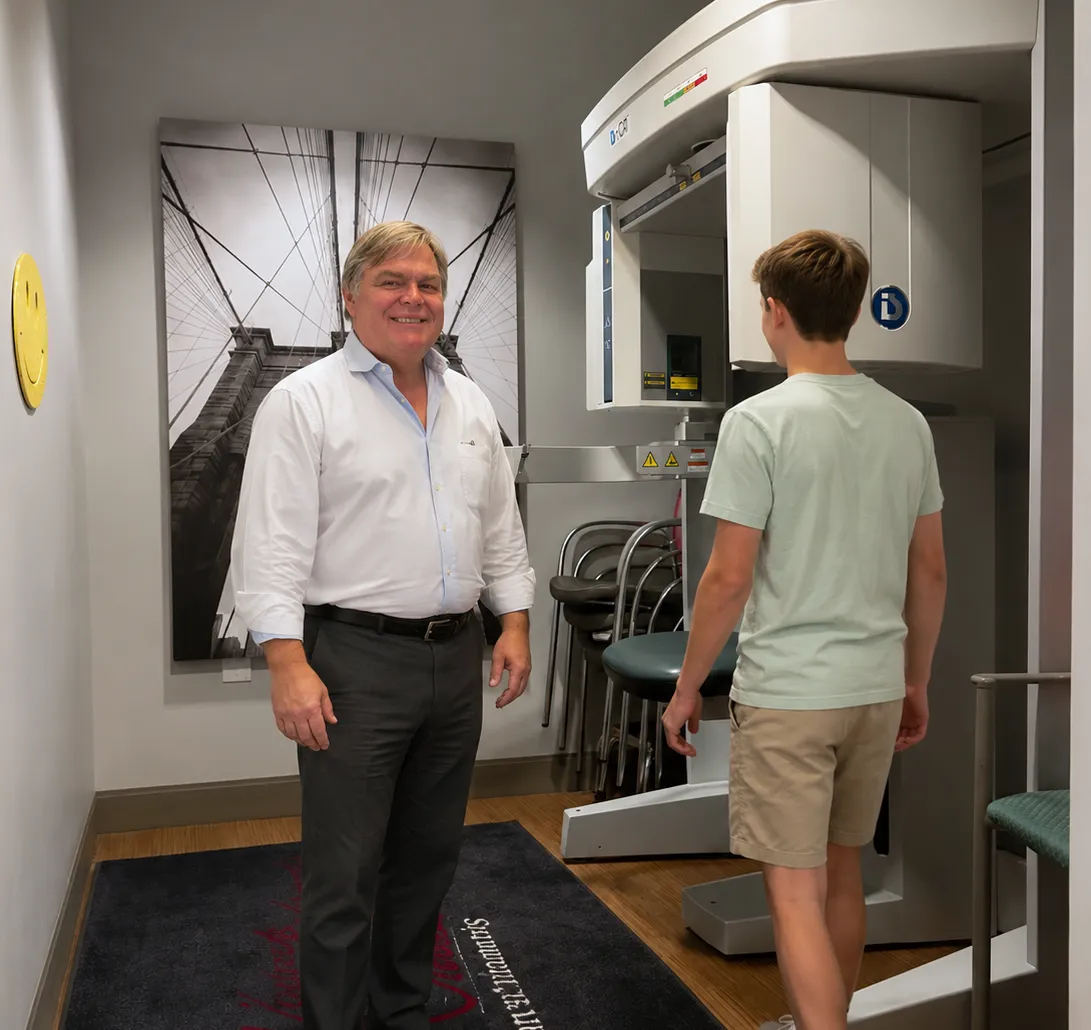 Dr. James Kendrick guiding a teen patient near the i-CAT imaging machine at Kendrick Orthodontics in Kissimmee, FL