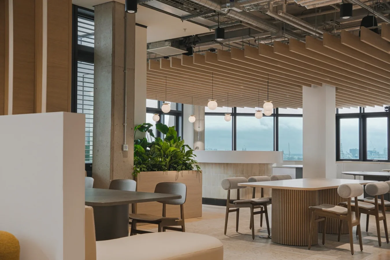 Office cafe area with a timber slat ceiling, banquette seating and sea views
