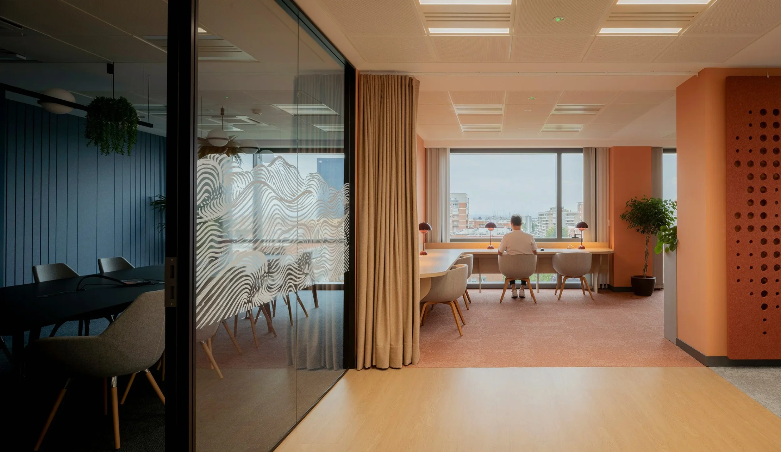 Executive meeting room with city views and a warm orange interior at Trainline's Madrid office