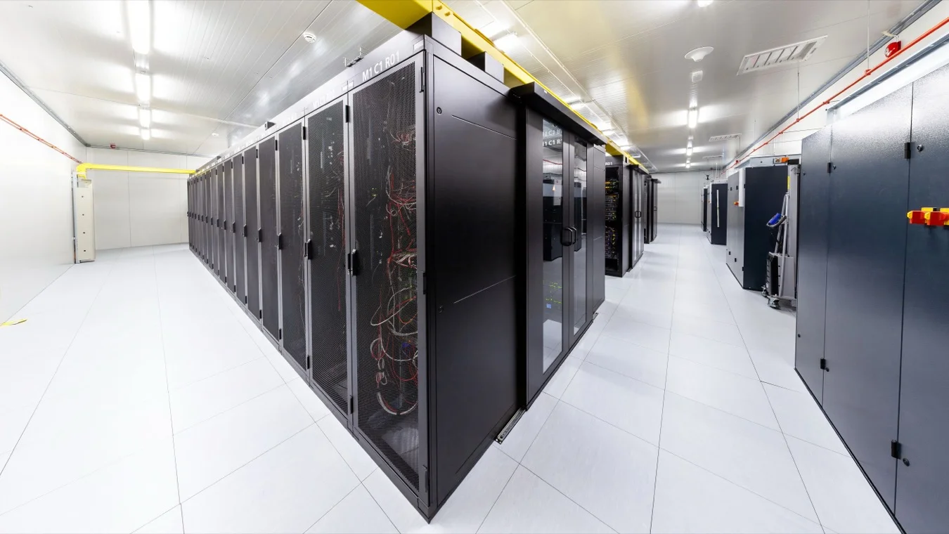 Data centre hall lined with rows of black server racks on a white floor