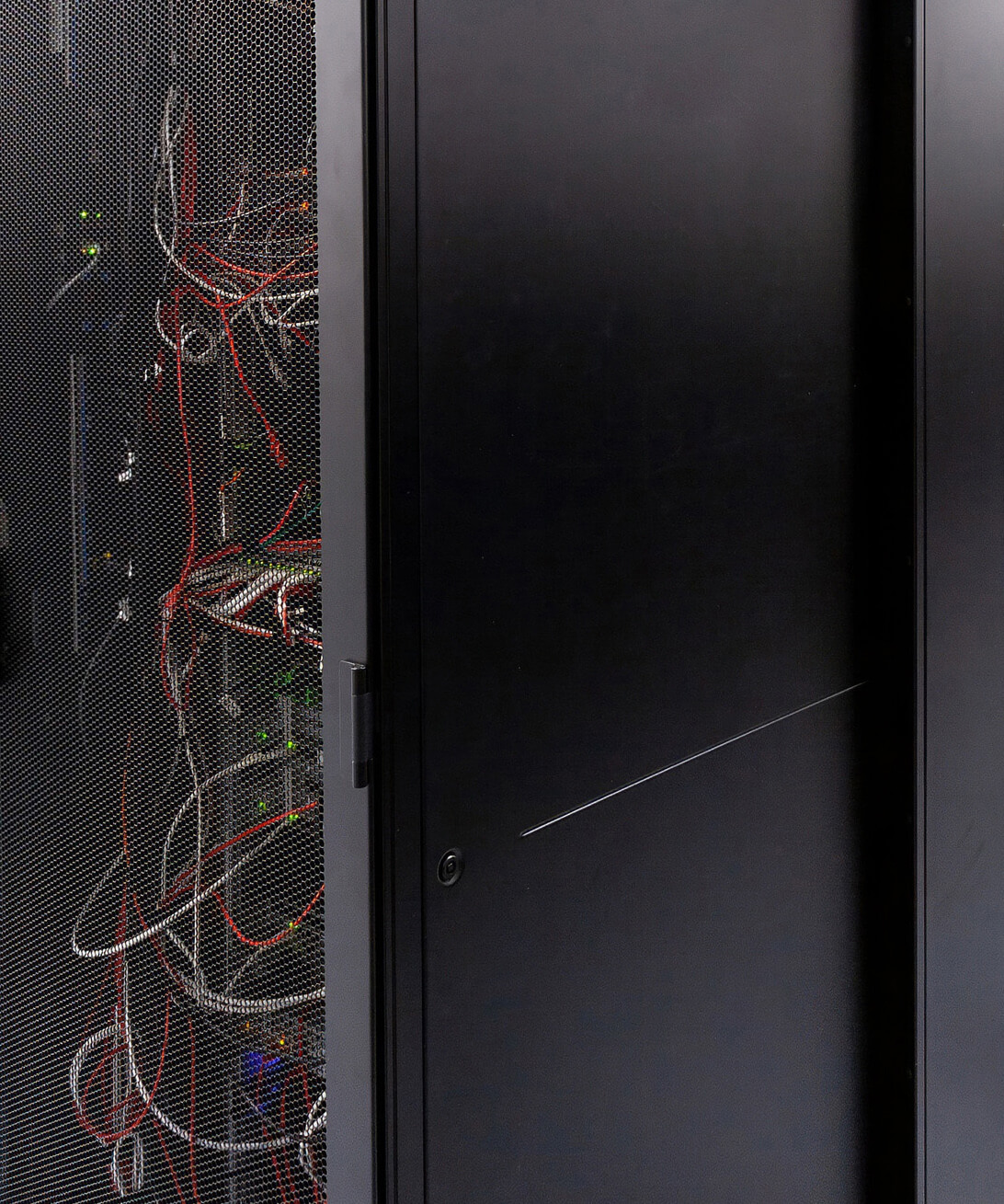 Close-up of a black server rack filled with red and grey network cabling