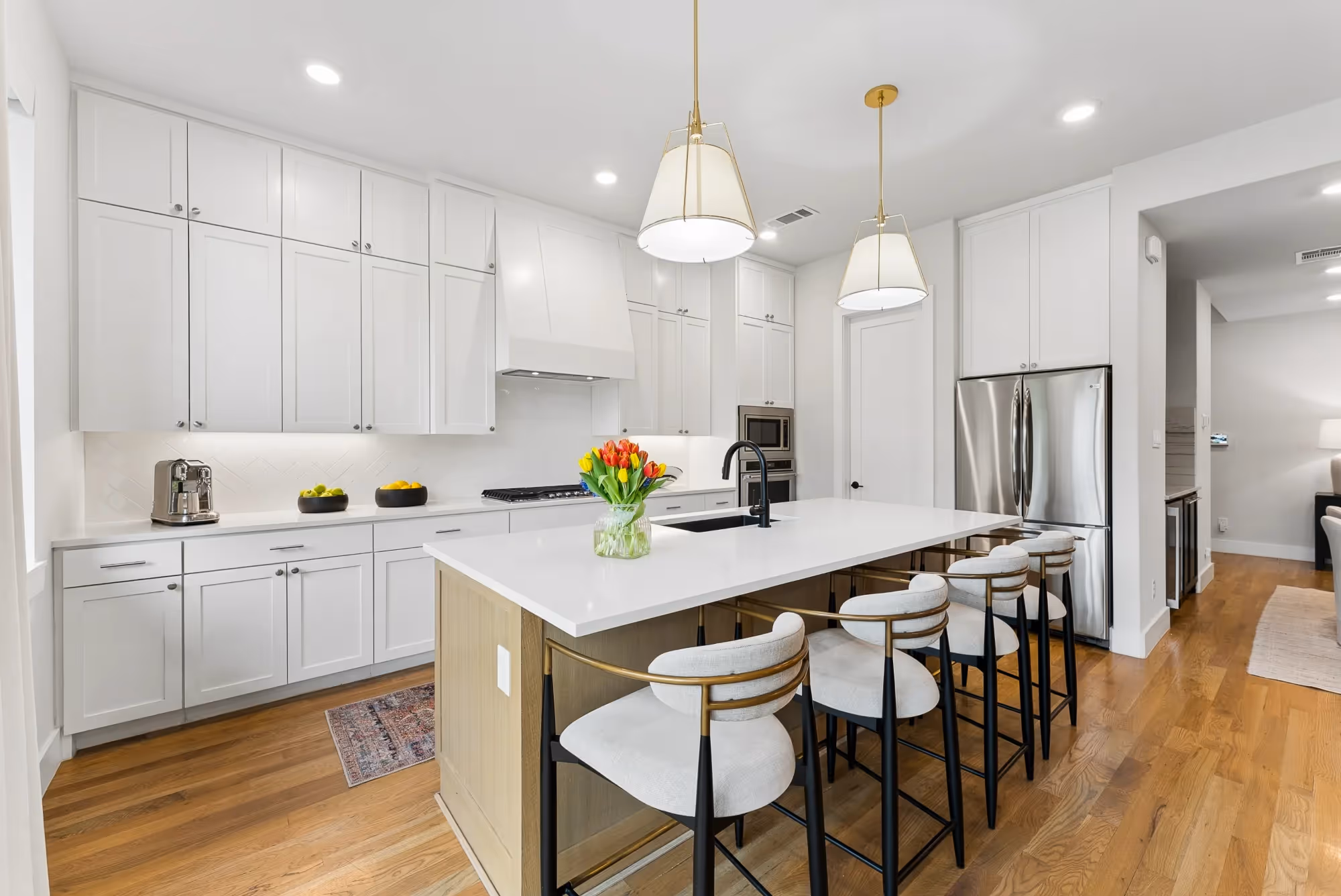 White kitchen island with pendant lights and bar stools