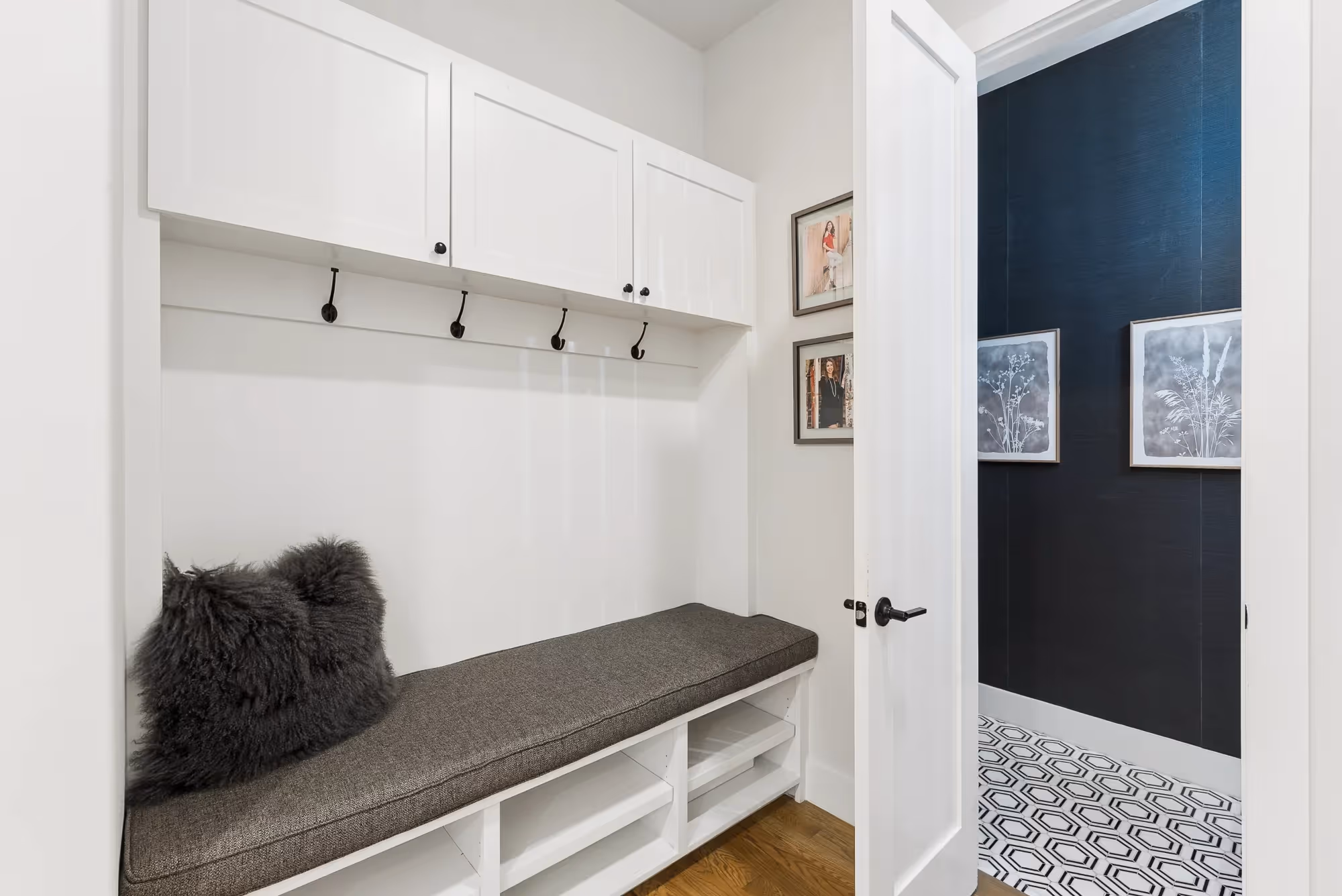 Mudroom bench with hooks beside open doorway