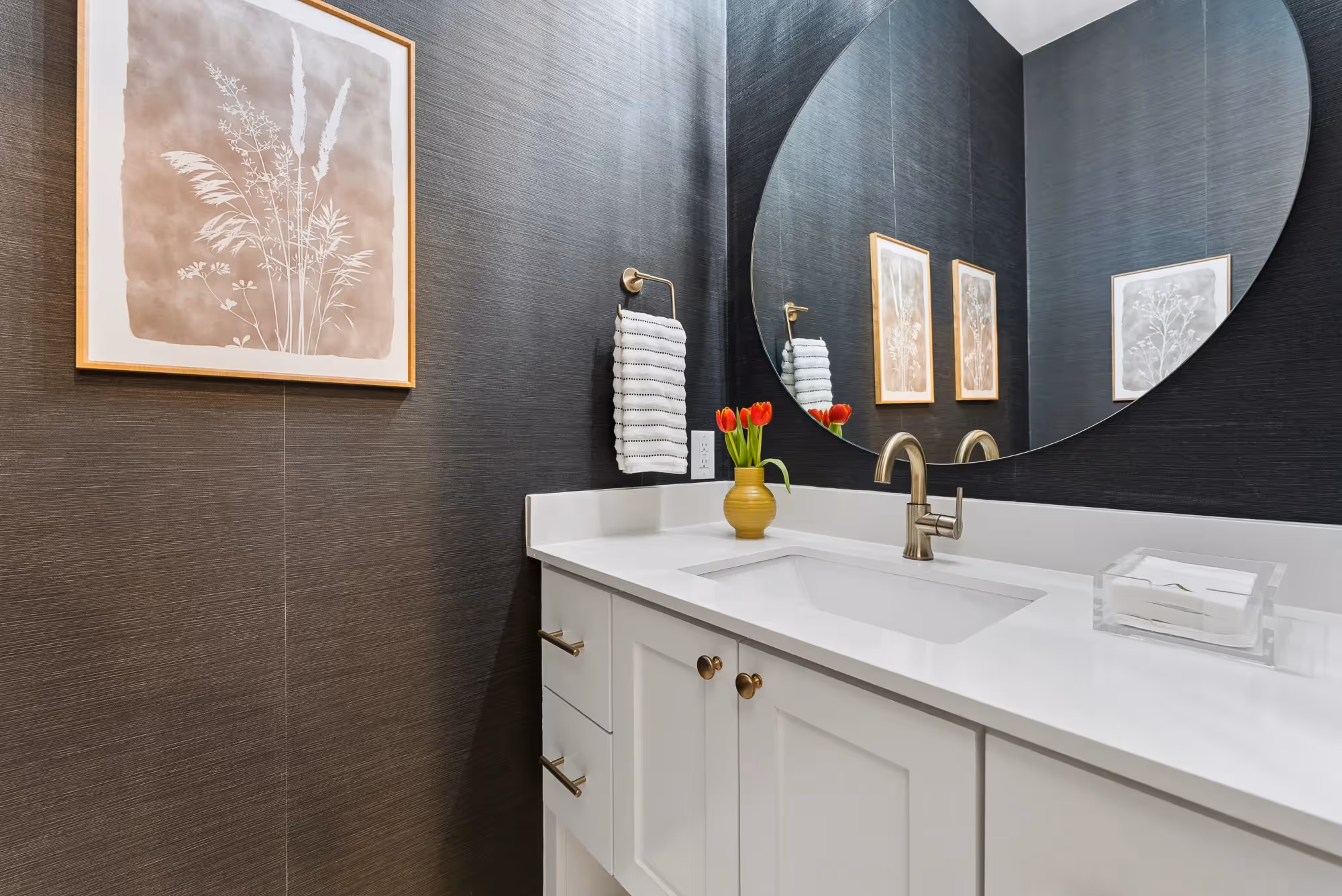 Modern bathroom vanity with round mirror and dark tile wall