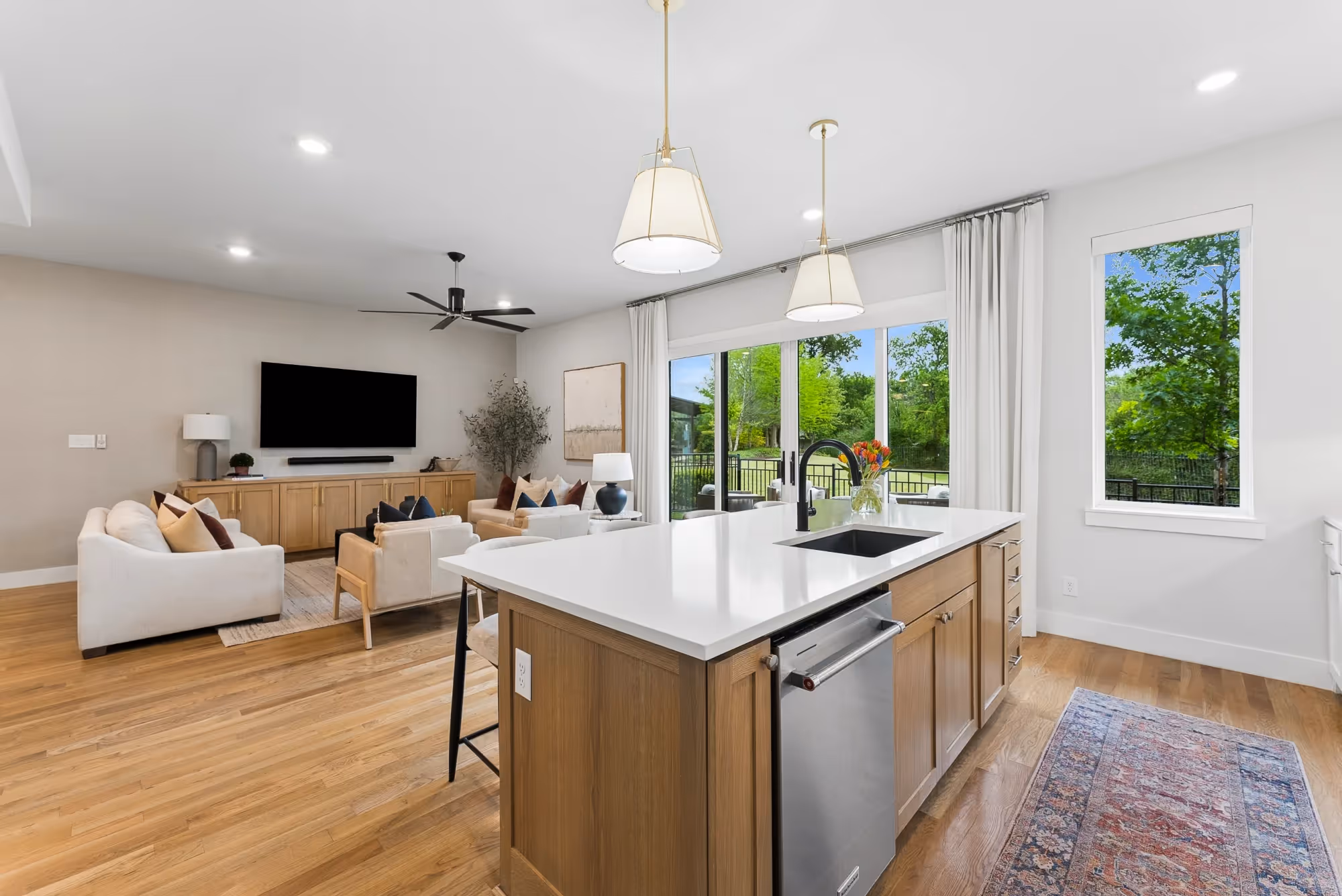 Open kitchen island overlooking bright living room with patio doors