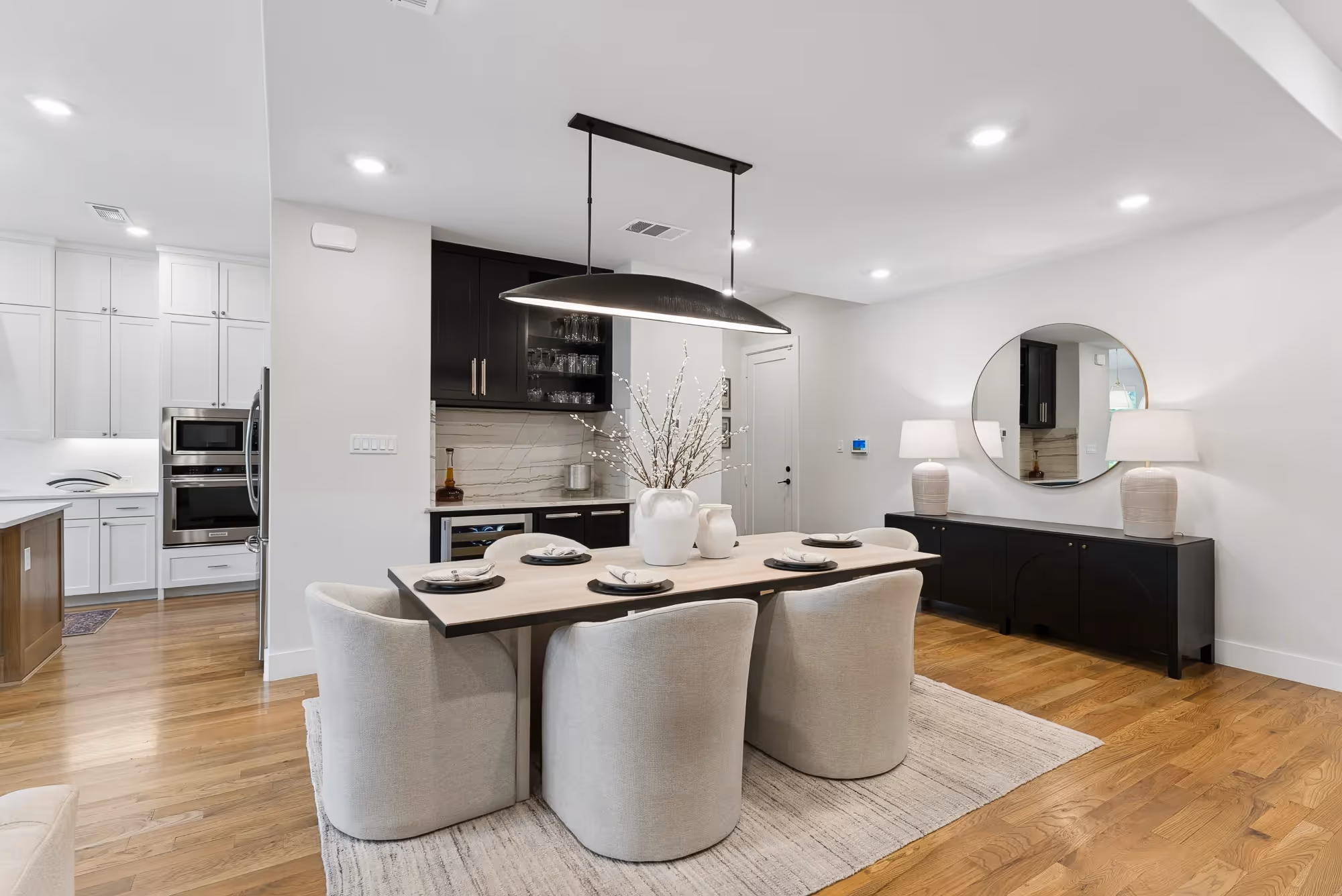 Modern kitchen with round island seating and black range hood