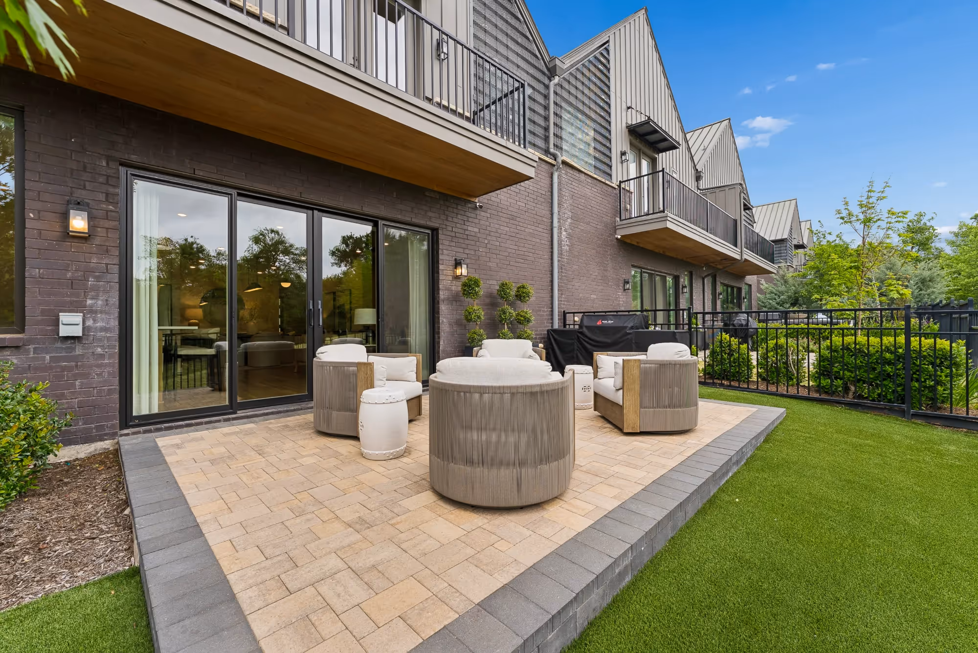 Outdoor patio seating beside modern house with lawn