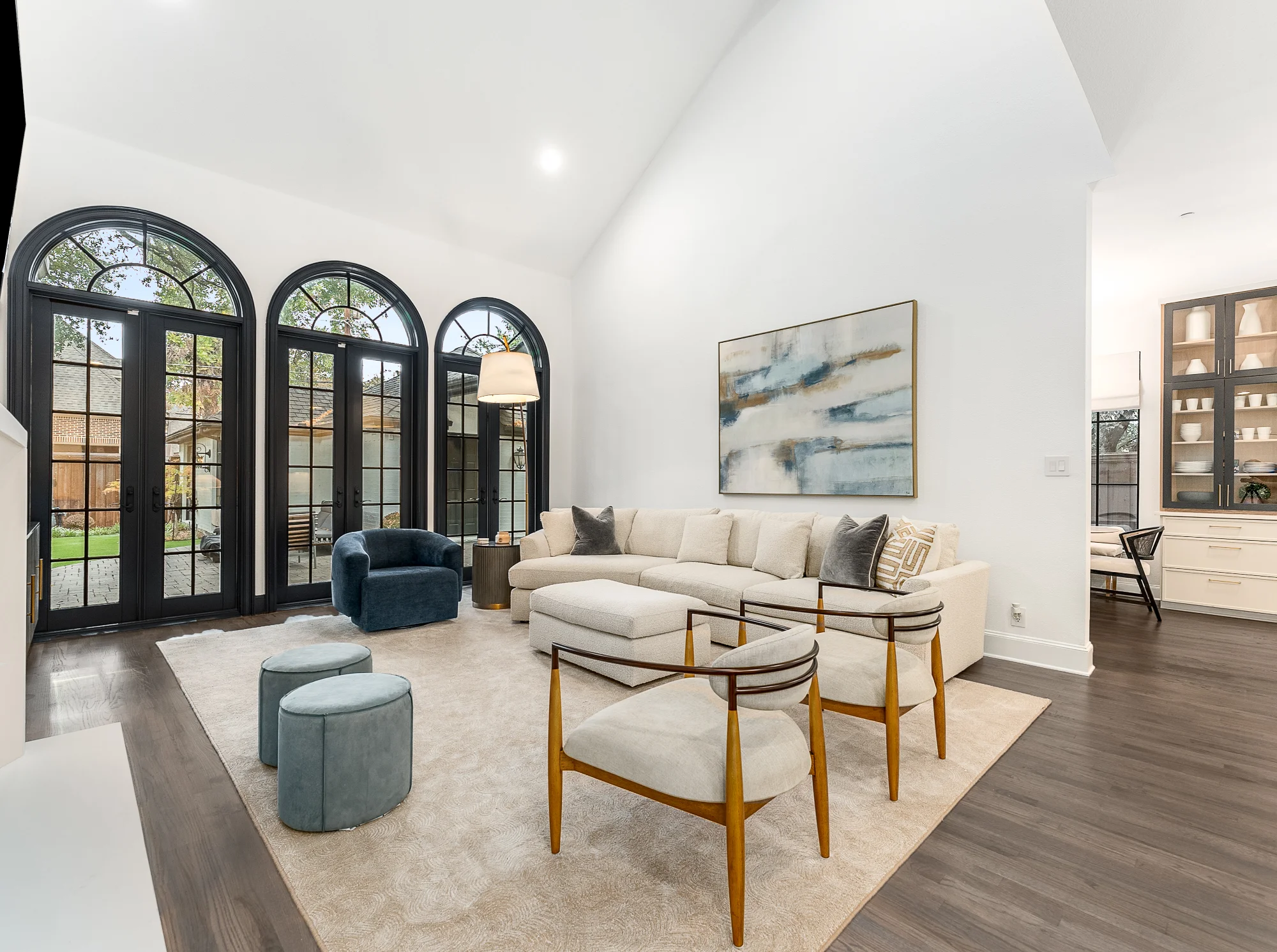 Living room with arched windows and light seating area