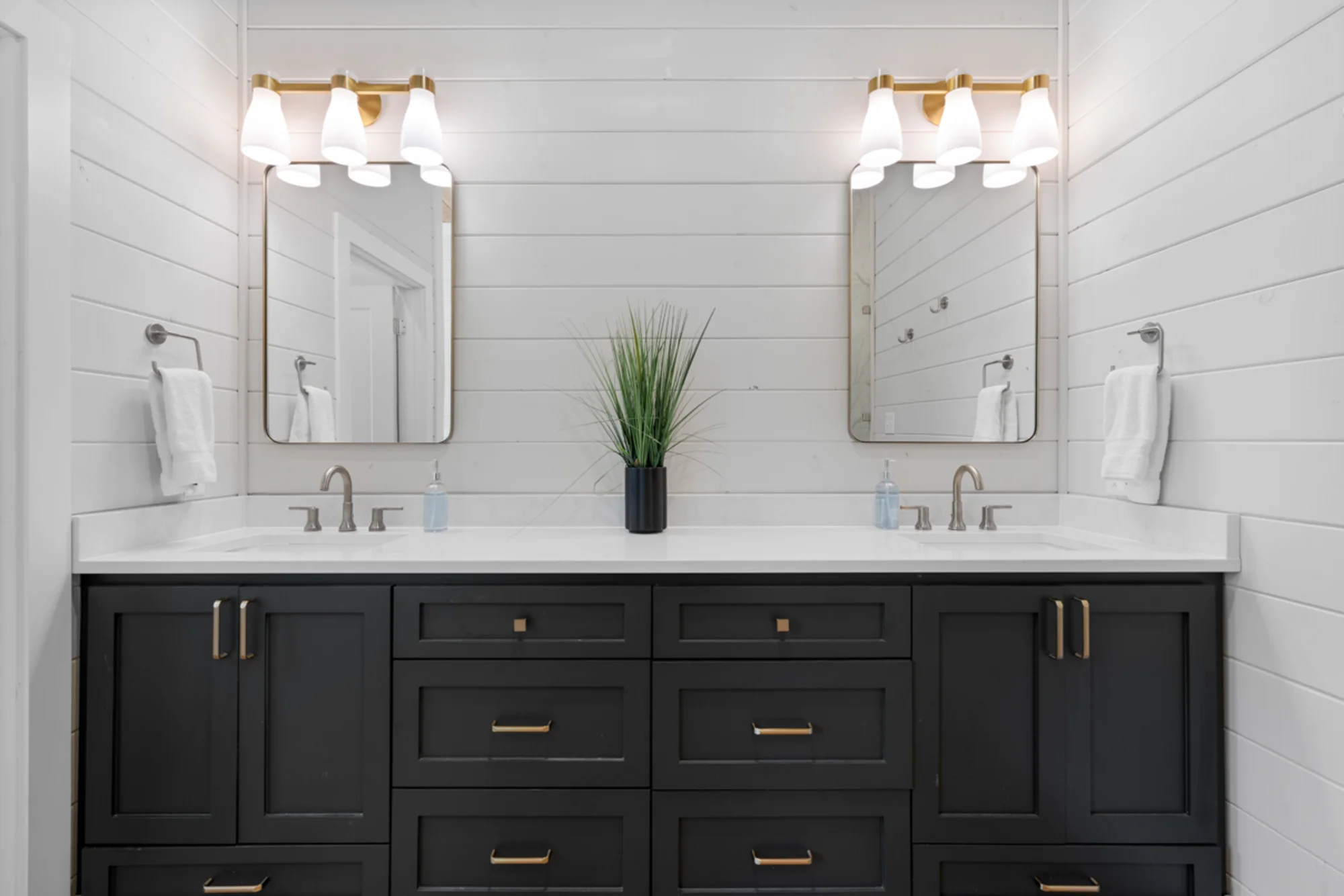 Modern double vanity bathroom with black cabinets and mirrors