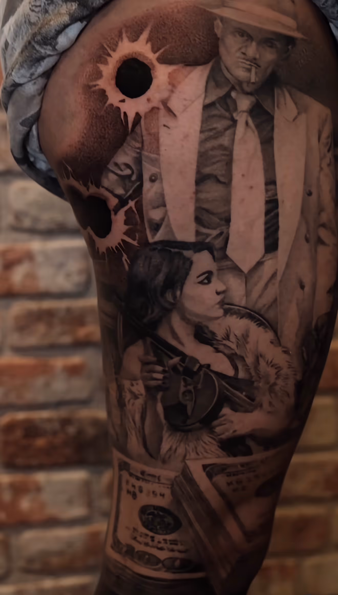 Detailed full sleeve tattoo of a large grinning face with a protruding tongue, a snarling wolf skull, a castle, and a grim reaper skull on a person's arm.