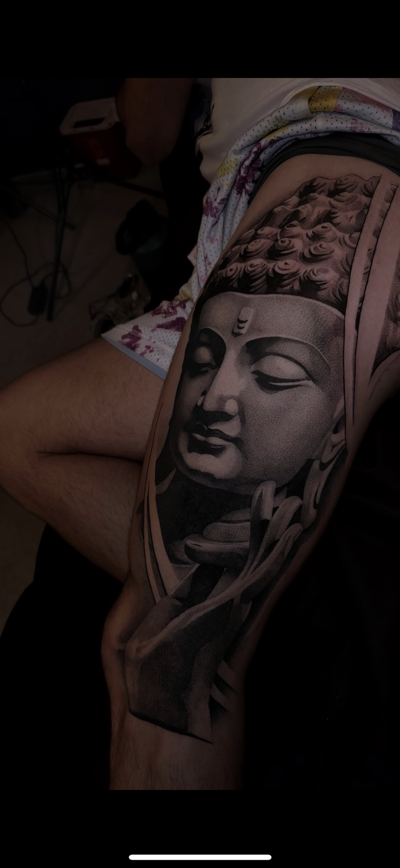 Tattoo on hand featuring a detailed, shaded face with an eye design and white highlights.