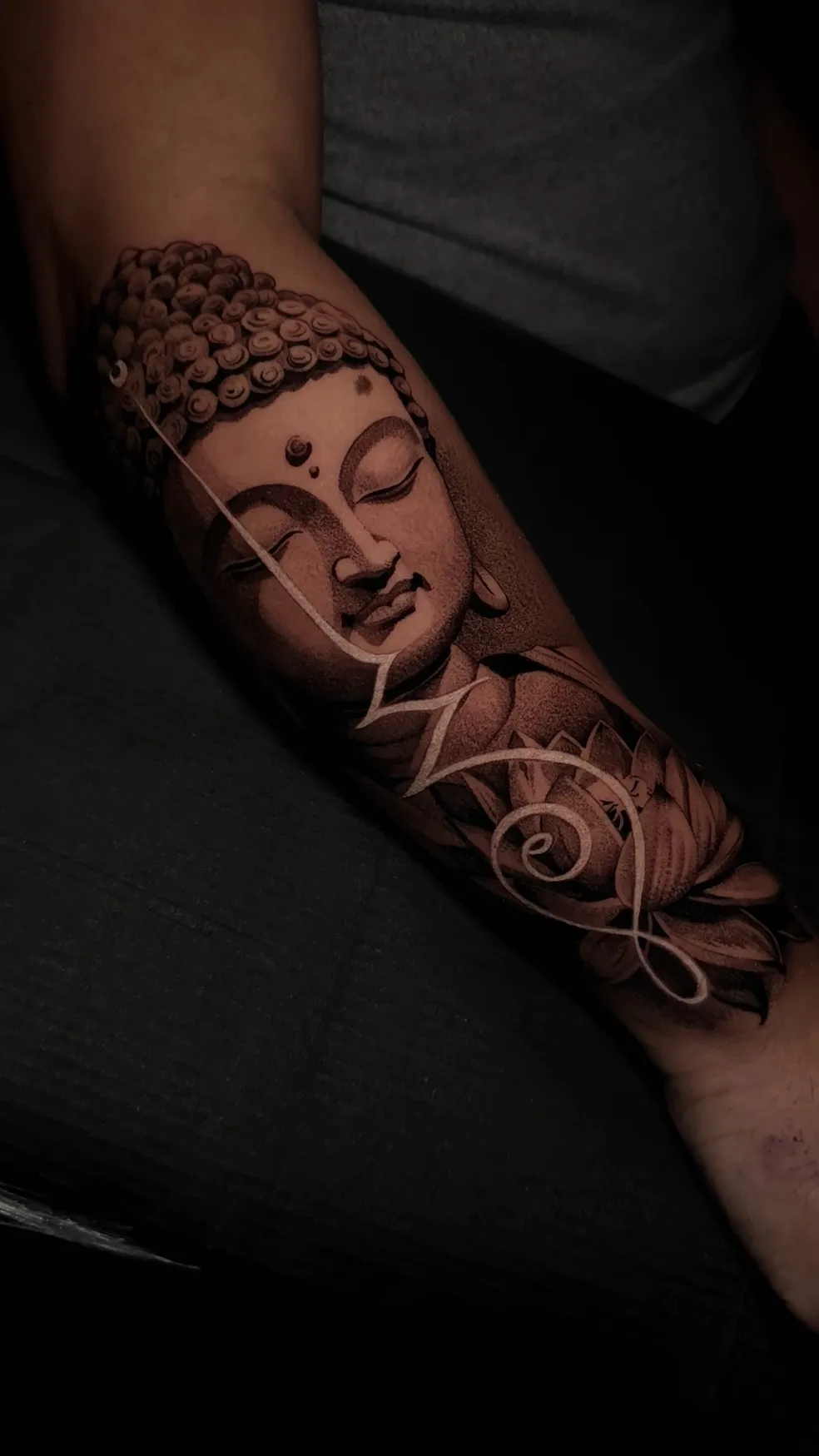 Tattoo on hand featuring a detailed, shaded face with an eye design and white highlights.