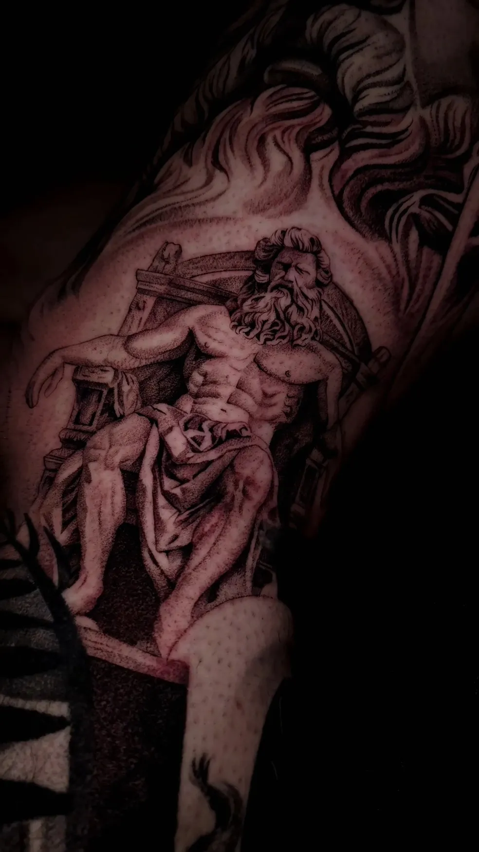 Black and gray tattoo of Lady Justice holding scales and sword on a person's forearm.