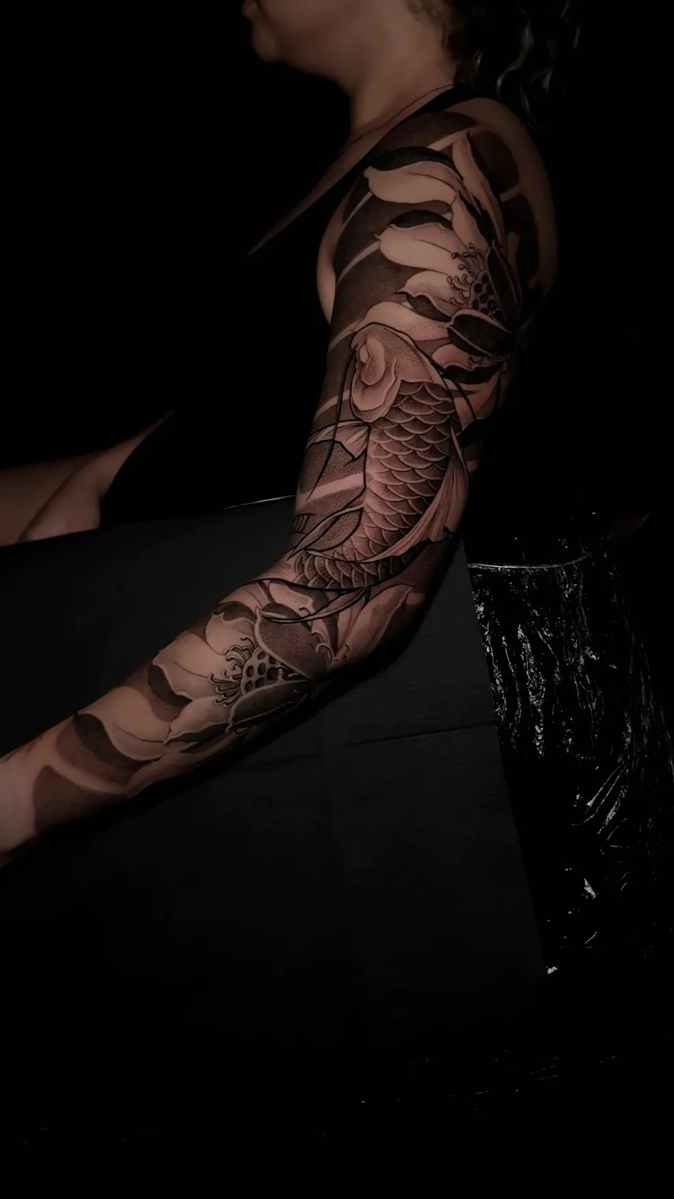 Tattoo on hand featuring a detailed, shaded face with an eye design and white highlights.