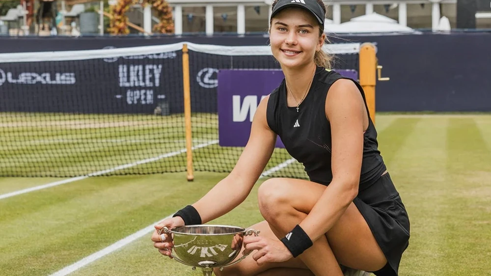 Iva Jovic crouches with the Ilkley Open trophy after winning her first WTA 125 title