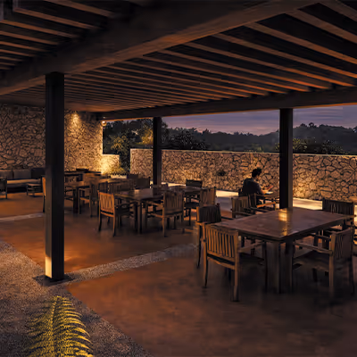 Restaurante al aire libre con mesas y sillas de madera bajo un techo con vigas expuestas durante el atardecer.