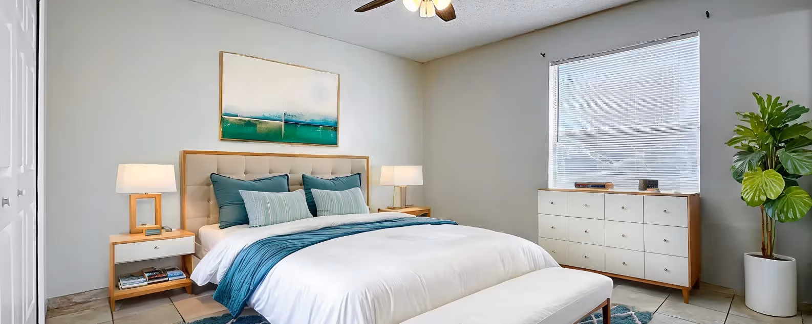 Bedroom with virtually staged furniture including bed, plant, and bedside table with lamp
