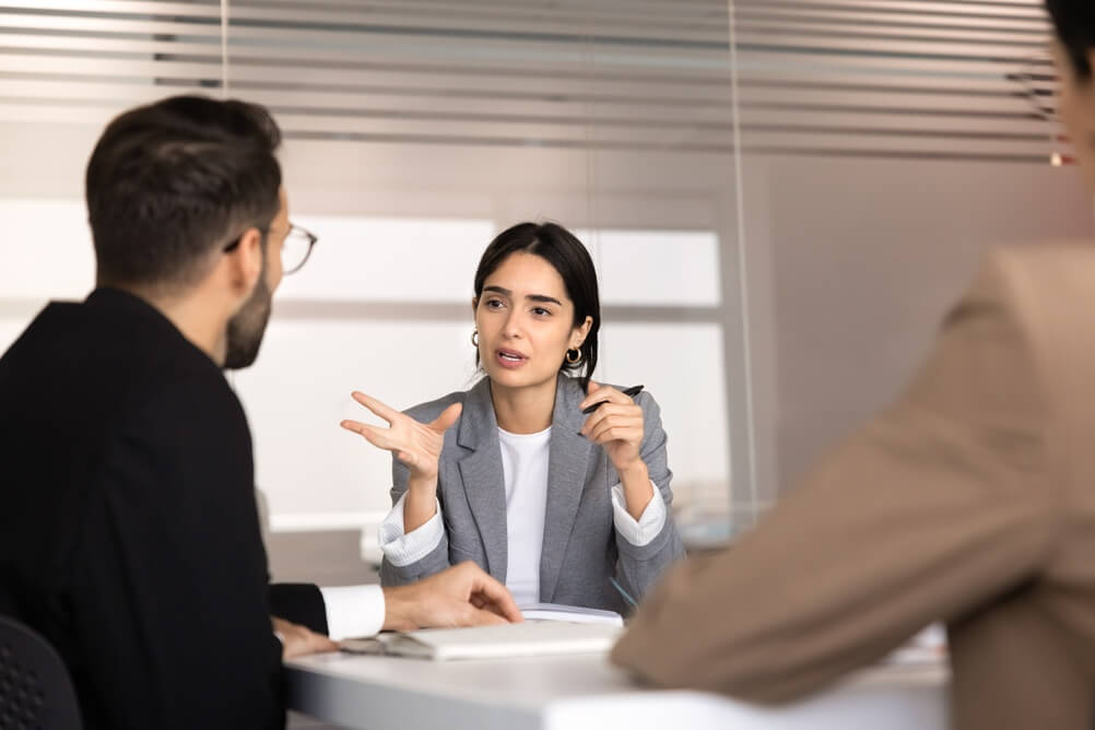 Professional woman consulting company clients, share information, planning strategy, explaining ideas and solutions with diverse team members during meeting in office. Business discussion, mentorship