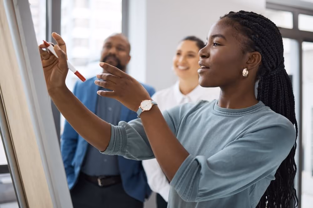 Black woman, business learning and whiteboard writing for company planning with strategy. African female employee, meeting and sales collaboration of staff working with teamwork and workshop idea