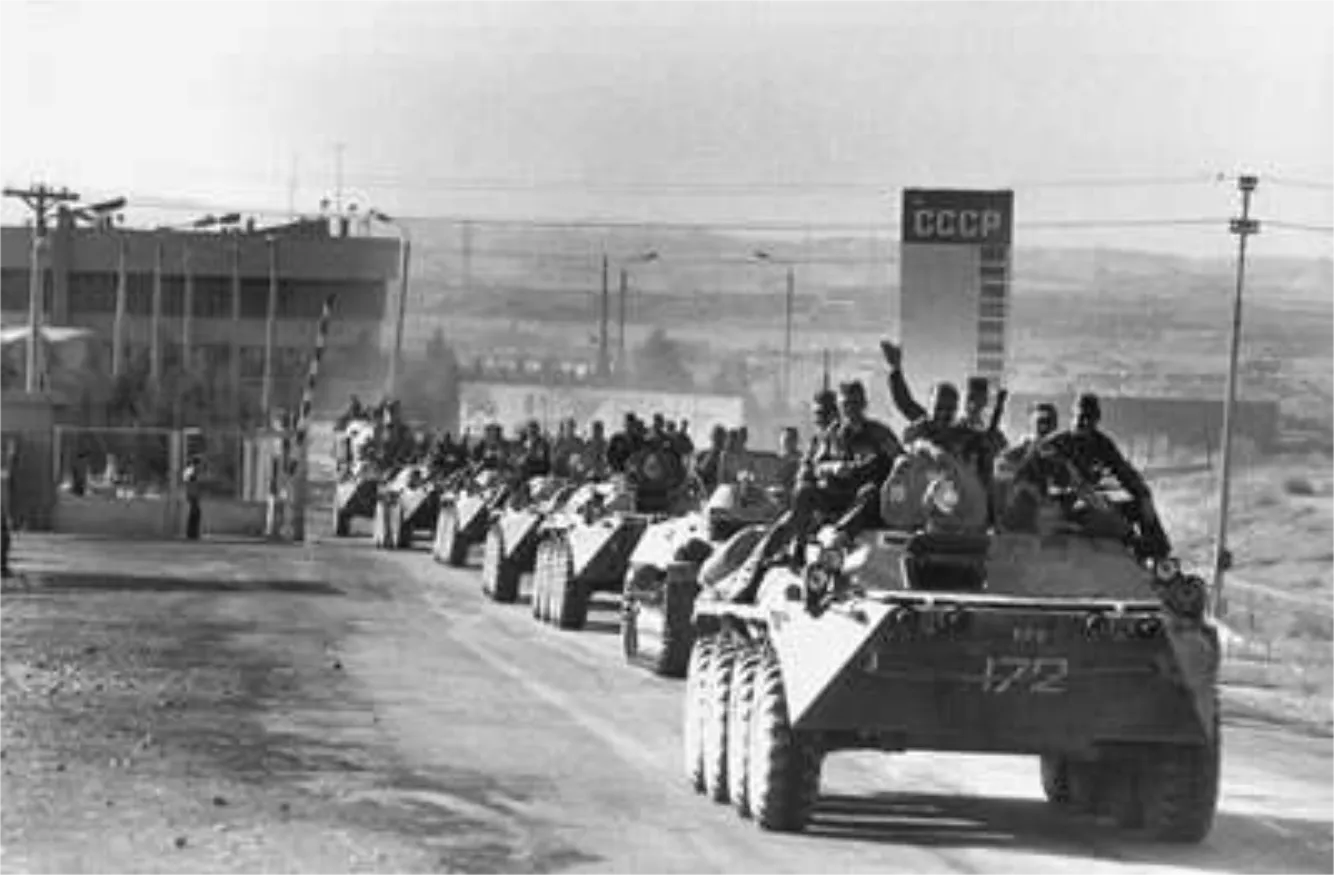 Line of Soviet armored personnel carriers with soldiers driving down a road near a checkpoint marked by a sign reading CCCP.