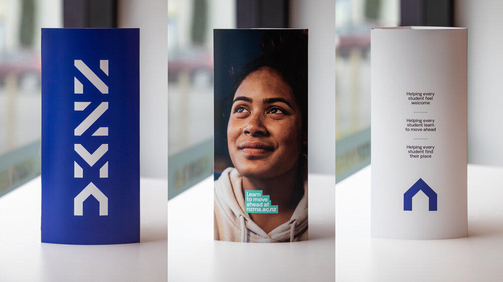 NZMA brochure: blue cover with white logo, portrait of a smiling student, and back panel with house icon.