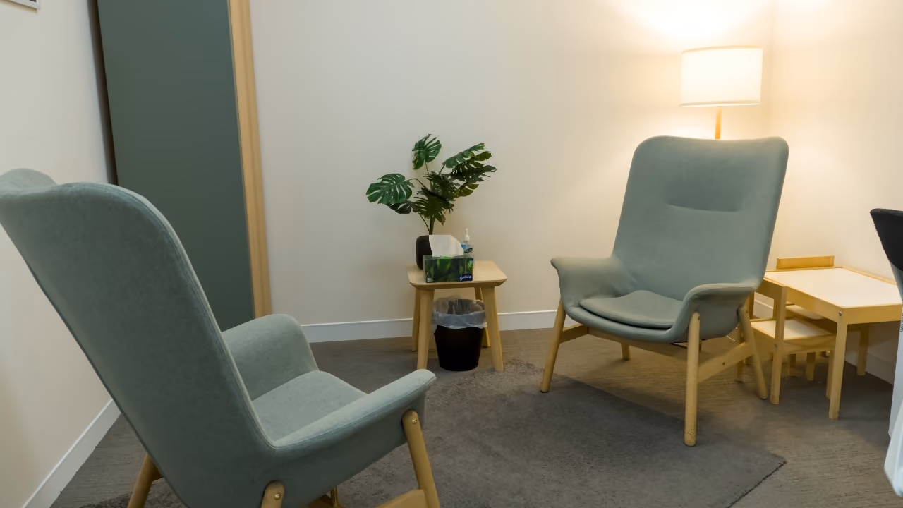 A calm psychology room with comfortable chairs and warm lighting.