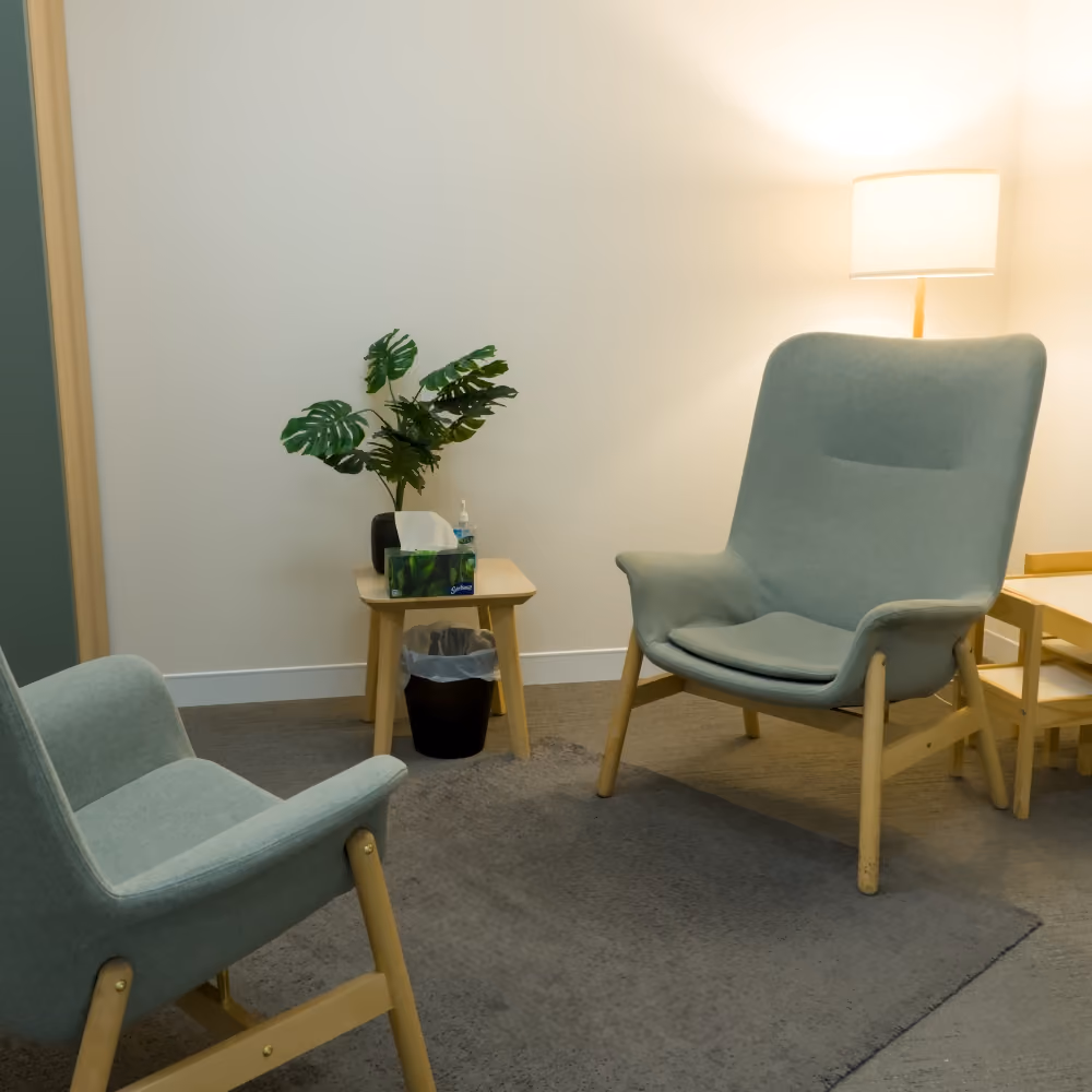 Calm psychology room with warm lighting and comfortable chairs.
